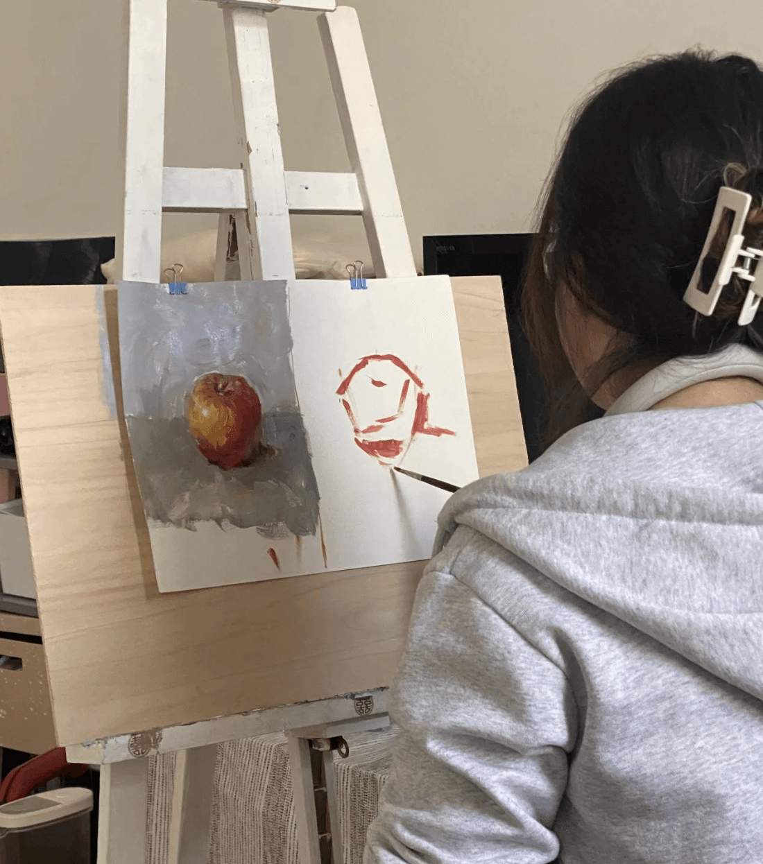 Kind malt mit einem Pinsel ein Bild.